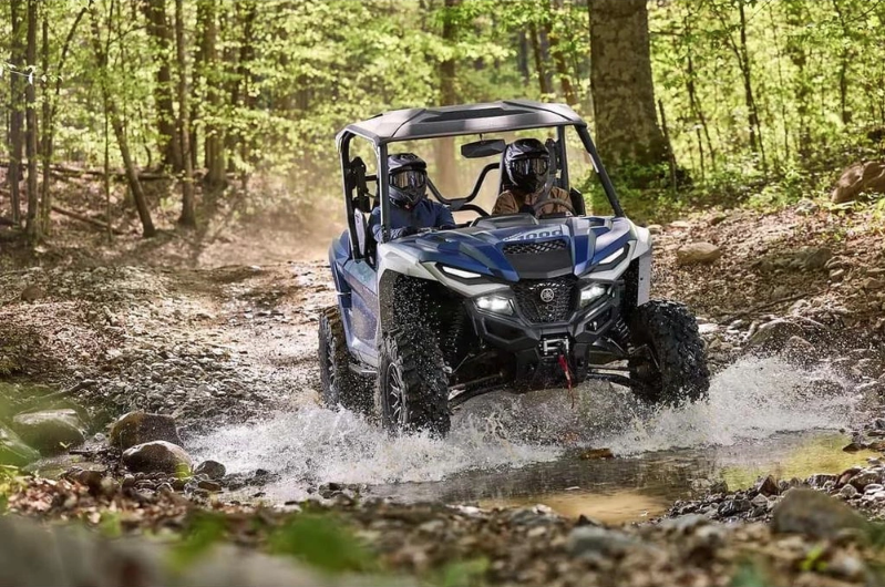 Yamaha Wolverine side-by-side crossing a creek in the woods